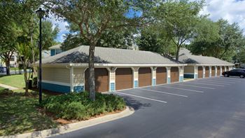 a building with a parking lot and trees in front of it